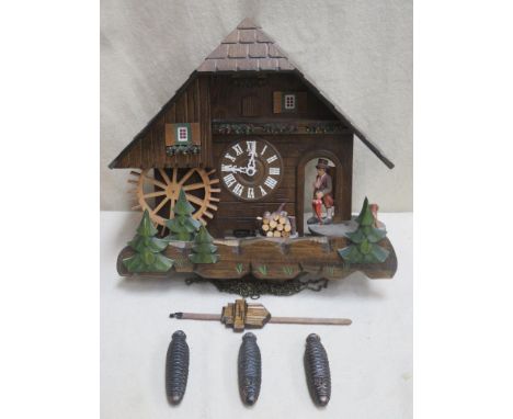 Vintage carved wooden cased cuckoo clock with automation, modelled on a European thatched chalet, with pendulum and three han