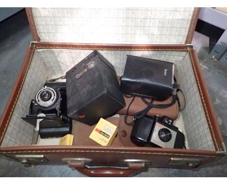 Mixed vintage cameras including a Kodak Brownie six-20 folding camera, with a briefcase, and other camera accessories. P&amp;