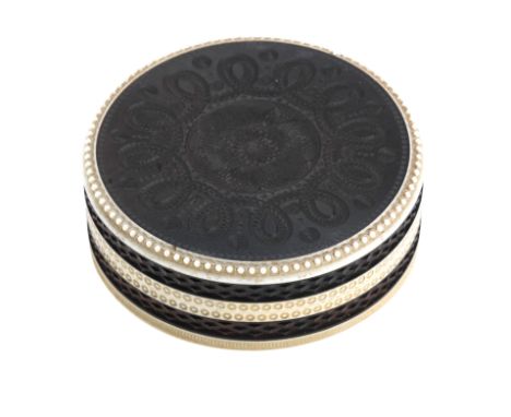 An early 19th century ebony and ivory patch boxOf circular form, carved with concentric designs, 10cm diameter, 4cm high (3 1