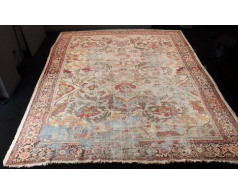 An antique Ziegler carpet in 'country house' condition - 19th century, with bold all-over floral and foliate decoration on a 
