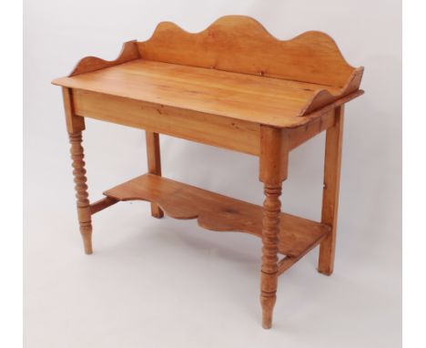 An antique waxed-pine wash-stand - the shaped, three-quarter gallery top raised on bobbin turned front supports with toupie f