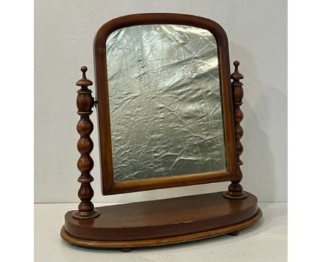 A Victorian mahogany toilet mirror - the arched plate on bobbin turned uprights with pawn finials, on a bowfront moulded base