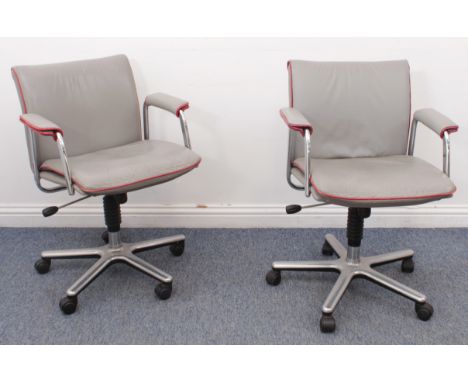 A pair of vintage light- grey leather swivel desk-chairs - 1980s, piped in red, with chrome arms, height adjustable, the cast