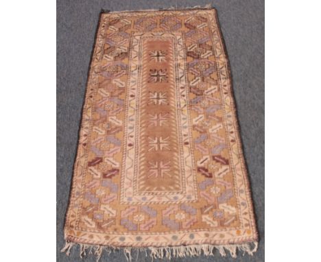 A small Turkish hand knotted wool rug - the central buff field with six star and cross medallions, within a broad border of r