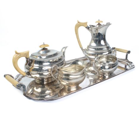 A George V silver four piece tea service - Viners Ltd, Sheffield 1934, of oval bombe form, comprising a teapot, hot water pot