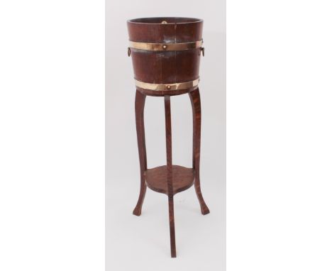 A brass-bound oak jardiniere on stand by R. A Lister &amp; Co. Ltd. of Dursley - with twin loose ring handles, the separate t