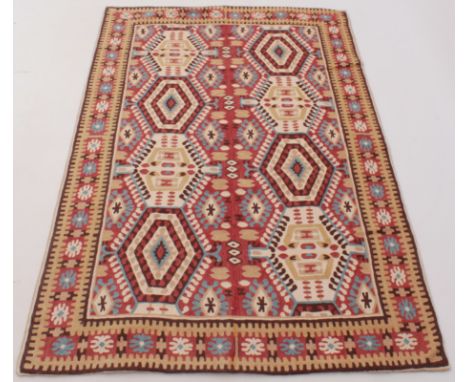 A flat weave rug - worked in shades of terracotta, light blue, ivory, buff and brown, 184 x 120cm.