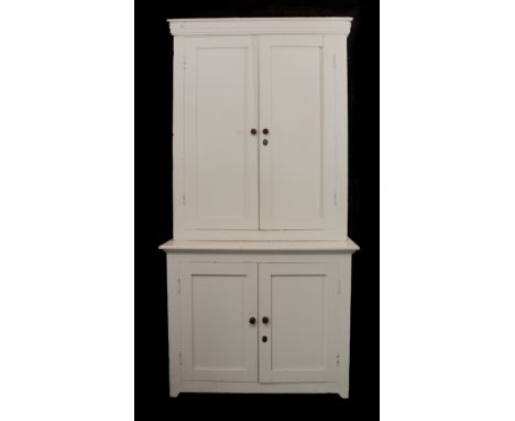 A white-painted two-part pine dresser or cupboard - early 20th century, the slightly flared cornice over a top section with a