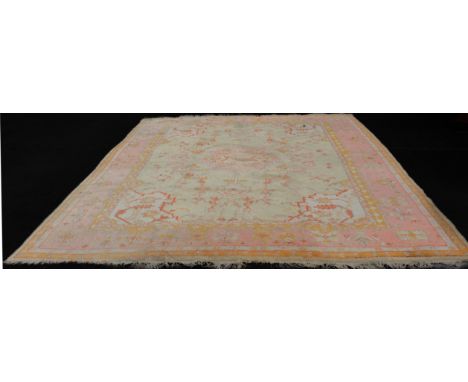 An antique Turkish Ushak carpet - the central pink pendant medallion on a very pale-green field with floral vines and stylise