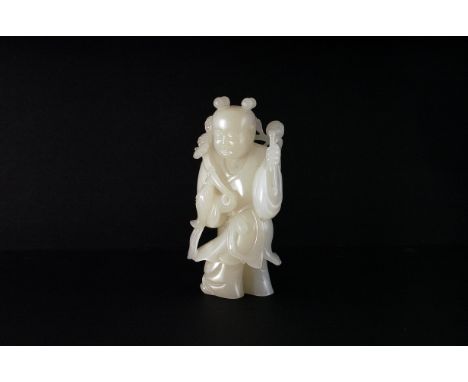 A fine Chinese jade carved figure, probaly 18th century, carved as a figure of a boy carrying branch and fish, approx 12cm Pl