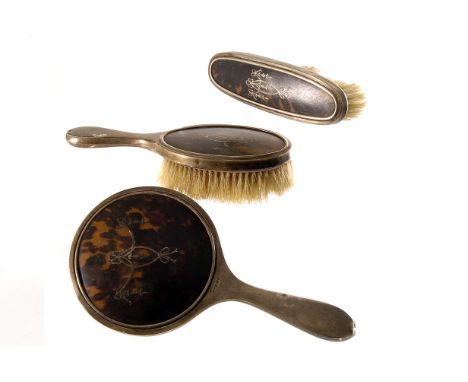 A George V silver and tortoiseshell three piece dressing table set, together with a set of six silver coffee spoons, a Victor