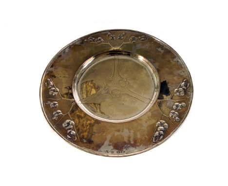 A fine George V Arts & Crafts style silver charger by Christine Connell, the circular shallow dish with raised design of cher
