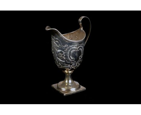 A George III silver cream jug by Stephen Adams, helmet shaped on square base, possibly later embossed, London 1793 