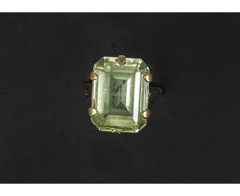 A 9ct gold dress ring, supporting a rectangular cut light green paste stone some small chips to the stone