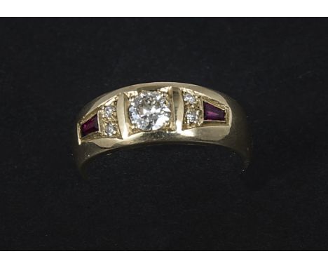 A 9ct gold diamond and ruby dress ring, with a central brilliant cut flanked by a pair of smaller examples and a baguette cut