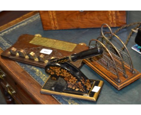 An early 20th century wire work and mahogany letter rack, 17.5cm wide;  a cast iron desk stamp;  a pipe rack (3)