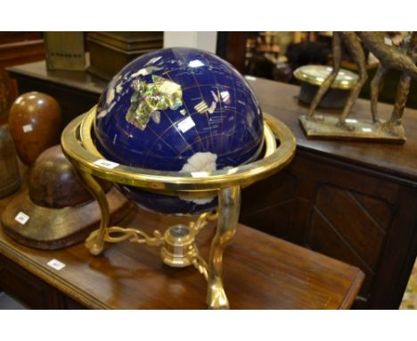A terrestrial globe inset with minerals and shells sat on a compass