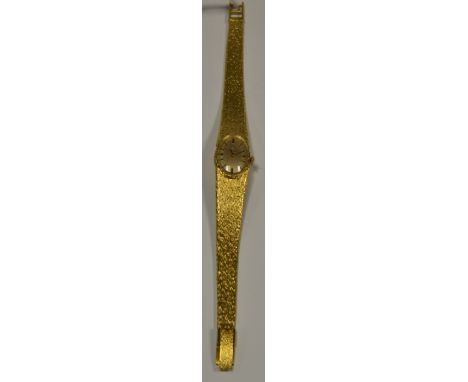 An 18ct gold Omega lady's wristwatch, brushed oval dial, baton markers, manual wind movement, integral textured bracelet stra