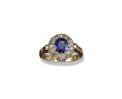 A sapphire and diamond cluster ring, the circular-shaped sapphire is set within a surround of rose-cut diamonds in gold, size