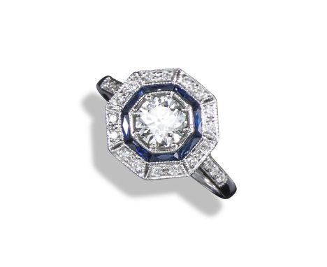 A diamond and sapphire cluster ring, centred with a circular-cut diamond weighing approximately 0.70cts within a surround of 