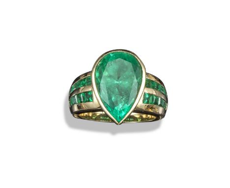 A yellow gold emerald-set dress ring, the pear-shaped emerald weighs approximately 7.40cts and is rubover-set in yellow gold,