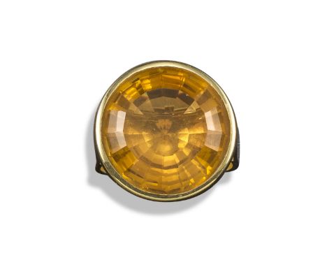 A citrine solitaire ring by Rudolf Heltzel, the circular-shaped citrine is rubover-set in yellow gold, on a plain polished go