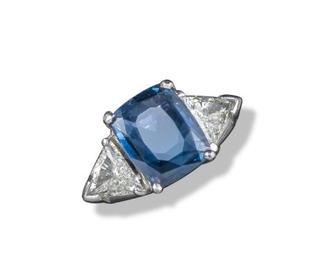 A sapphire and diamond three stone ring, the cushion-shaped sapphire flanked with triangular-shaped diamonds in white gold, s