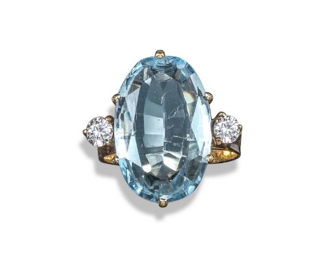 An aquamarine and diamond three-stone ring, the oval-shaped aquamarine is claw-set in gold with two round brilliant-cut shoul