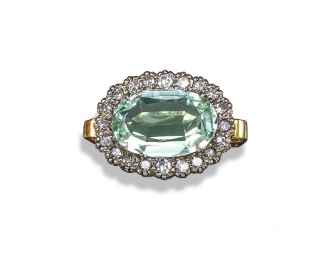 An aquamarine and diamond cluster ring, the oval-shaped aquamarine set within a surround of circular-cut diamonds in yellow a
