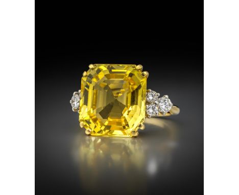 A sapphire and diamond ring by Cartier, the octagonal step-cut yellow sapphire weighs 13.34cts and is set in yellow gold and 