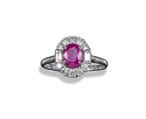 A ruby and diamond cluster ring, the oval-shaped ruby set within a surround of round brilliant-cut diamonds with baguette-cut