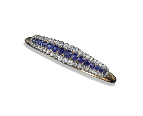 A late Victorian sapphire and diamond bangle, set with a central line of graduated cushion-shaped sapphires within border of 