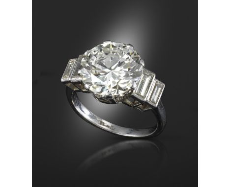 A diamond ring, set with a circular brilliant-cut diamond weighing 5.50cts (known weight), flanked with graduated baguette-sh