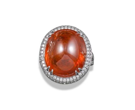 A hessonite garnet and diamond ring, the sugarloaf garnet cabochon set within concentric surround of diamonds, with diamond b