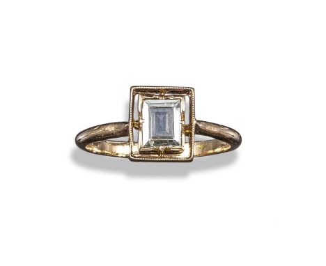 A diamond solitaire ring, the baguette-shaped diamond in set within concentric border, in yellow gold, size K