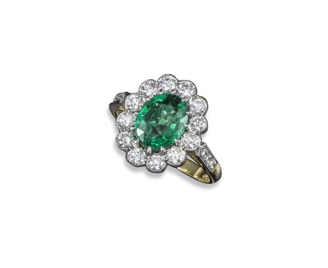 An emerald and diamond cluster ring, the oval-shaped emerald weighs approximately 1.45cts and is set within a surround of twe