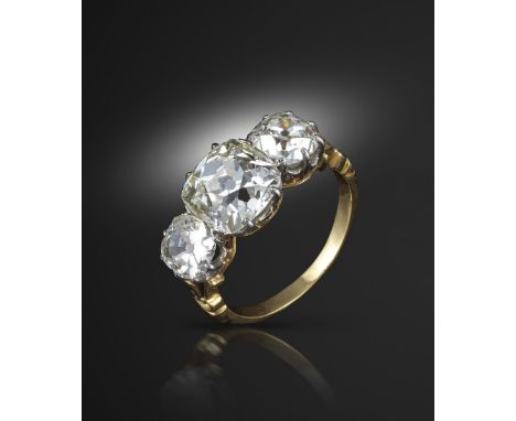 A diamond three-stone ring, the centre cushion-shaped diamond weighs 3.38cts (known weight) and is set with two old circular-
