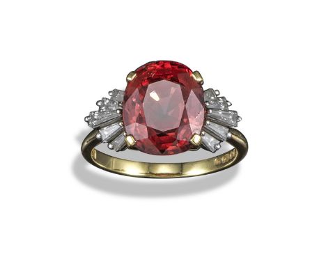 A spinel and diamond ring, the oval-shaped spinel flanked with graduated tapered baguette-shaped diamonds in yellow gold, siz