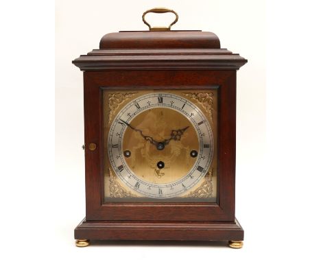 A twentieth century mahogany cased mantel clock with a silvered chapter ring featuring Roman and Arabic Numerals, striking on