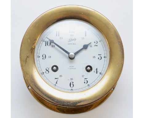A Schatz brass cased 11cm bulkhead clock, with an enamel dial featuring Arabic Numerals and stamped 'Ships Bell', eight day m