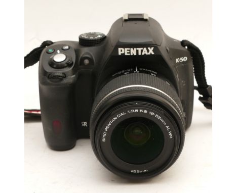 A Pentax K-50 digital camera with a Pentax DA L f/3.5-5.6 18-55mm lens, in original box.