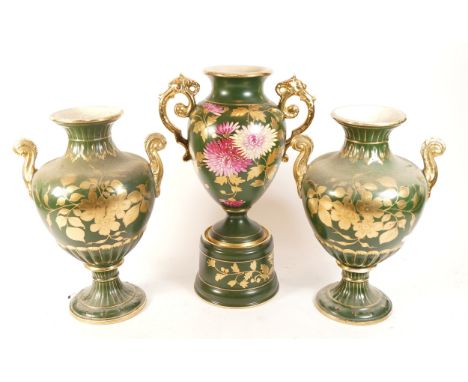 A Victorian style three piece ceramic garniture, comprising of a three urns, the central urn resting on a pedestal and decora