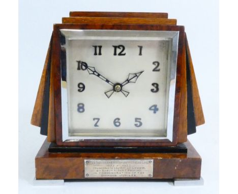 An Art Deco mantel clock, housing an eight day manual wind English movement, with a dedication plaque attached to the base, i