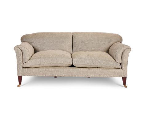 AN EDWARDIAN MAHOGANY AND UPHOLSTERED SOFA  BY HOWARD & SONS, CIRCA 1905  Of 'Chaplin' type, the castors stamped 'Howard & So