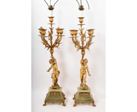 Pair of gilt metal and alabaster candelabra, with putto columns issuing five lights, raised on plinth bases, the metalwork si