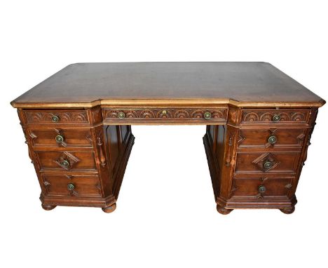 Early 20th century oak twin pedestal desk, of inverted breakfront outline, with slides and eight various drawers about the ca