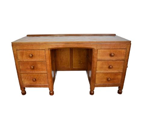 Robert 'Mouseman' Thompson oak desk, with adzed top and six drawers on faceted bun feet. 137cm wide x 51cm deep x 74cm high, 