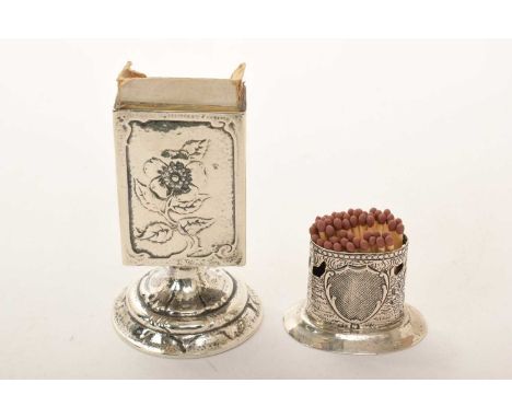 Edwardian silver match box holder of vertical rectangular form, with embossed floral decoration, on a pedestal base (London 1