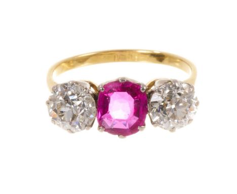 Fine ruby and diamond three stone ring with an oval mixed cut ruby measuring approximately 7mm x 6mm x 2.5mm, flanked by two 