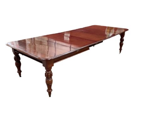 Large Victorian mahogany extending dining table, the rounded rectangular pull-out top on knopped legs and ceramic castors, to